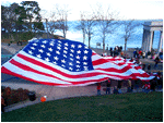  saturday at the giant thanksgiving parade in downtown plymouth. above water street, rippling in the offshore breeze, was the largest american flag i've ever seen. when they lowered it, people scrambled to keep it from touching the ground.  
